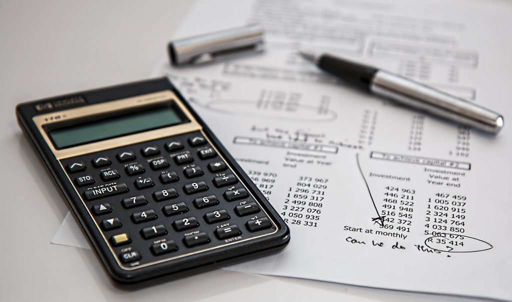 A calculator, pen, and balance sheet.