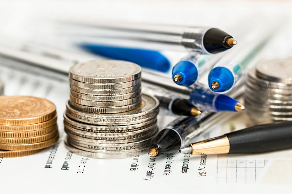 Coins, pen, and a balance sheet.